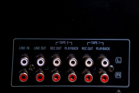 Black phono preamplifier with RCA connectors, ground terminal, power input jack, close-up view, High-fidelity audio equipment, Quality Essential gear for audiophiles, analog device for turntable