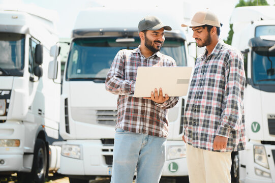 Indian truck drivers discussing logistics plan using laptop