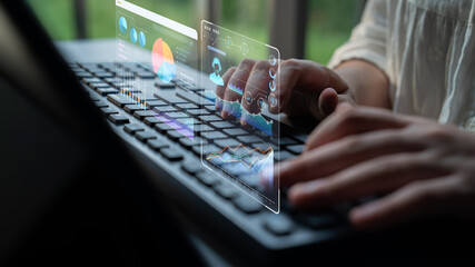 Hands typing on keyboard with digital data visualization and charts displayed for remote work and...