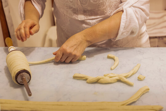 Woman preparing dough with rolling pin on kitchen countertop for baking