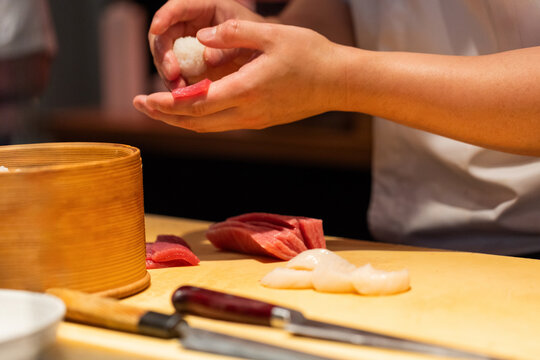 Skilled chef preparing sushi with fresh ingredients and bamboo steamer