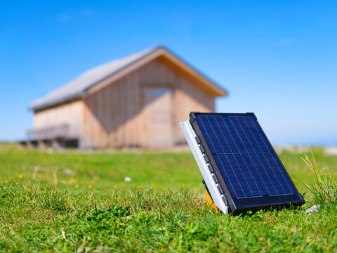 Solar panels installed on the ground in front of a house. Clean renewable energy system for autonomous living in a rural area.