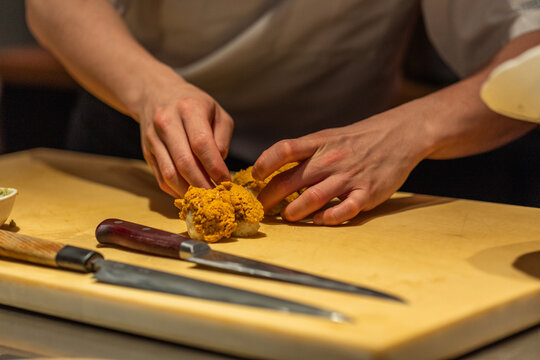 Chef preparing fresh ingredients on wooden cutting board in kitchen