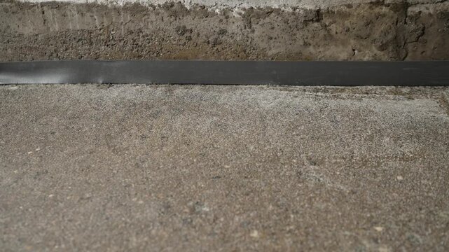 Slow pan over waterproofing membrane at base of concrete wall and floor