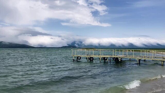 Peaceful lakeside pier with mountains in background. Sevan lake, Armenia