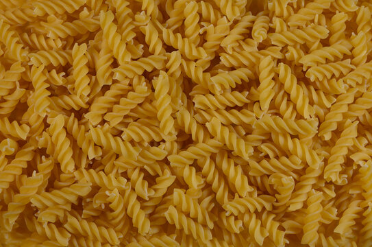 Commercial food photography of a top-down background of dry fusilli pasta