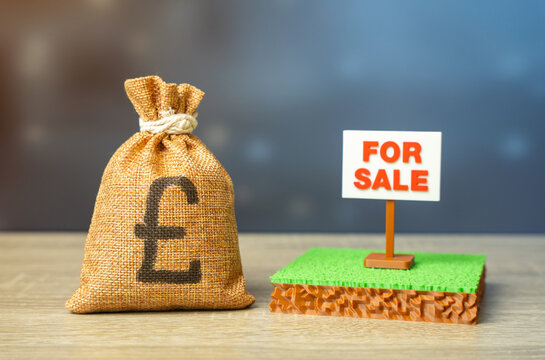 An British pounds money bag and a plot of land for sale. Land for construction or business. Mortgage. Bank collateral.