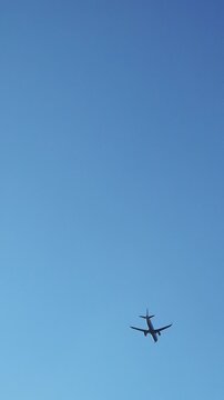 Airplane flying across clear blue sky