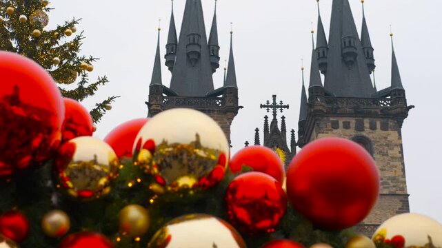 Christmas market decoration in prague old town square. Shiny red and gold christmas ornaments reflecting the historic old town square in prague, with the church of our lady before tyn