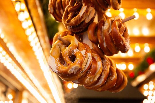 Bretzels sal&eacute;s suspendus &agrave; un stand de march&eacute; de No&euml;l, ambiance chaleureuse
