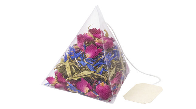 Pyramid tea bag with dried rose petals and cornflower, herbal floral tea infusion, organic loose leaf tea blend in mesh sachet isolated PNG with Transparent Background