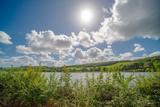 Fowey River landscape in Cornwall under a bright sunny blue sky with fluffy clouds