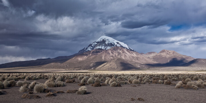 Sajama volcano mountain peak under dramatic storm clouds in Bolivia
