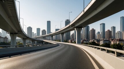 Obraz premium Empty elevated highway curves toward modern city skyline. Concrete overpasses span across urban landscape with tall skyscrapers and buildings under clear sky.