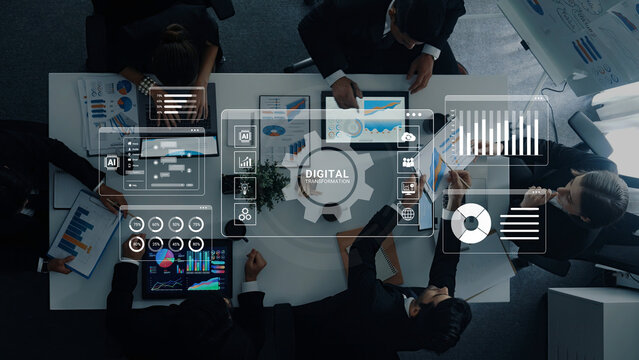 Business Team Engaging in Data Analysis with Digital Interface Graphics on a Conference Table in a Modern Office Setting. Glyphic.