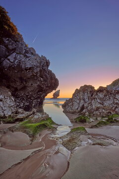 Low tide at Playa de Buelna Beach during a spectacular, fiery dawn with a rock-framed view of 'El Pic&oacute;n' limestone pinnacle. Llanes-Asturias-Spain-078