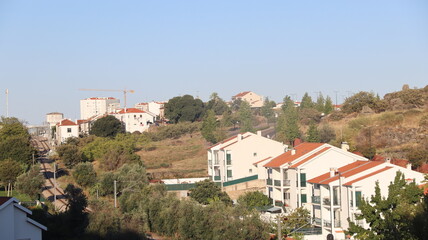 Fototapeta premium CASTELO BRANCO, PORTUGAL - AUGUST 22, 2026: General view of Castelo Branco city in the Beira Baixa region of central Portugal Residential buildings and railway tracks in a suburban landscape