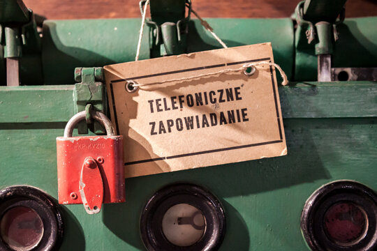 Announcing by telephone sign, red padlock, and vintage green railway interlocking machine mechanism