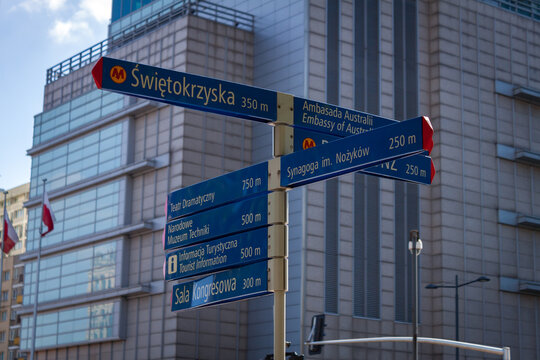 Tourist directional street signpost in downtown Warsaw with distances to Świętokrzyska metro station and city landmarks
