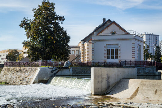 Historic Maison de l'Eau building with a concrete weir and waterfall on the Huisne river in Le Mans France