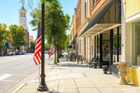 Broad Street, the main street of shops and cafes through the historic downtown of Camden, South Carolina, with the King Haigler Clock Tower and Opera House building in view.