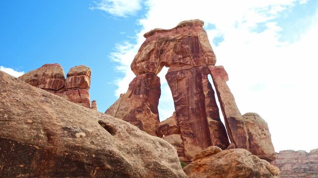 Vast panoramic vista reveals the monumental sandstone form of Druid Arch rising among rugged spires in Canyonlands National Park Utah
