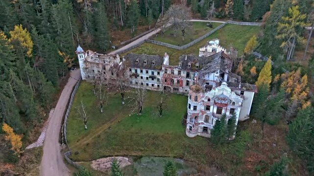 Aerial view of abandoned historic grand hotel surrounded by forest