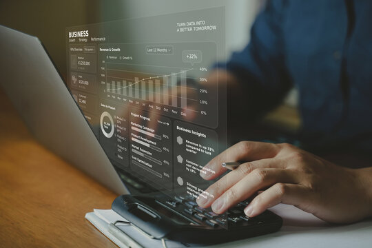 Business person working on laptop and using calculator with virtual financial display and sales insights