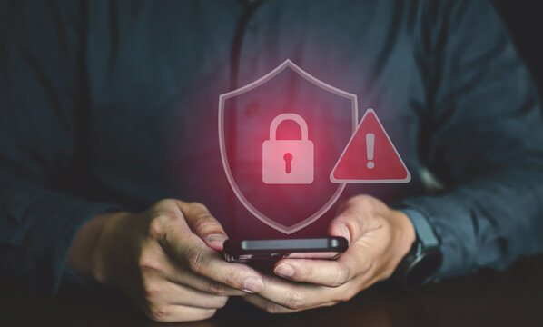 Person holding smartphone with red shield lock icon and warning exclamation mark for data security alert