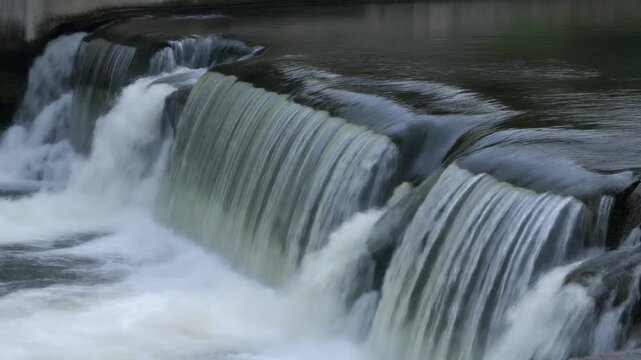 Dam overflow crest with a continuous stream