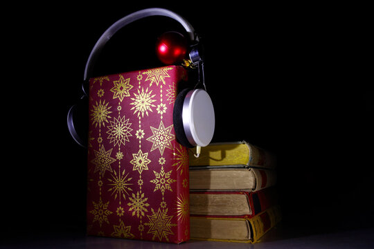Giving audiobooks for christmas with books,christmas decoration and vintage headphones.Gift,present,christian holiday concept, copy space.