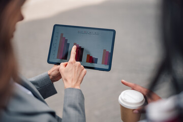 Businesswoman discussing company performance data on digital tablet with colleague during an outdoor meeting © Zamrznuti tonovi