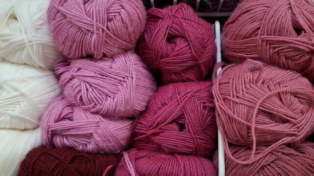 White and pink yarn skeins stacked together in close view. Knitting material, handmade craft, cozy hobby, soft texture, creative leisure.