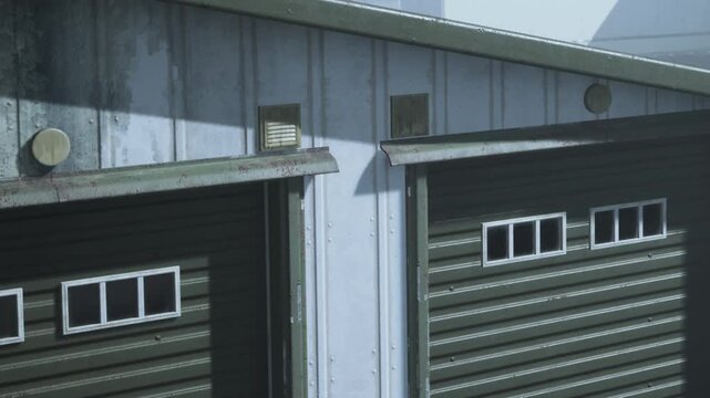 Two weathered storage units stand side by side in a tranquil countryside. Sunlight casts gentle shadows, highlighting their rustic charm and sturdy design amid lush greenery.
