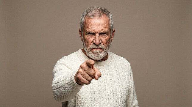 Stern elderly man with white beard points finger accusingly at viewer