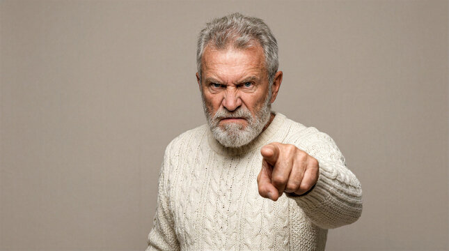 Angry senior man with beard pointing finger directly at camera