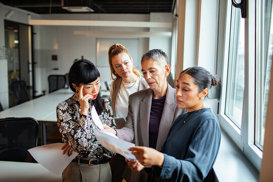 Team of businesswomen reviewing documents in modern office