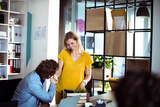 Smiling coworkers shaking hands in modern office