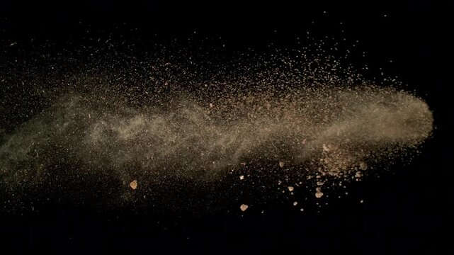 Super Slow Motion Shot Flying Soil Isolated on Black at 1000fps.
