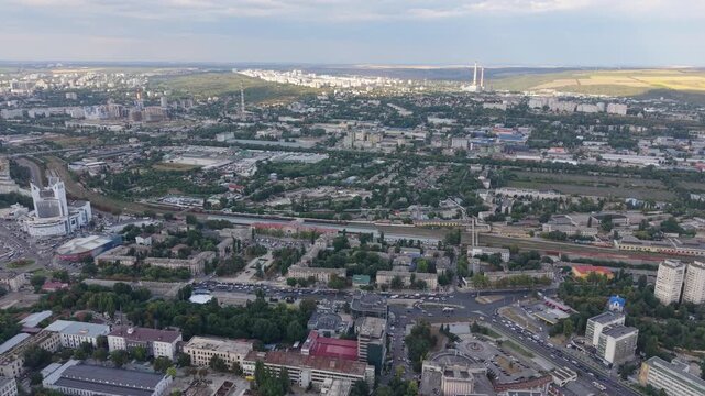 CHISINAU, MOLDOVA - AUGUST 11, 2026: Drone rises above Chisinau revealing a wide aerial panorama of residential districts, busy roads, railway infrastructure and the urban landscape of Moldova's capit