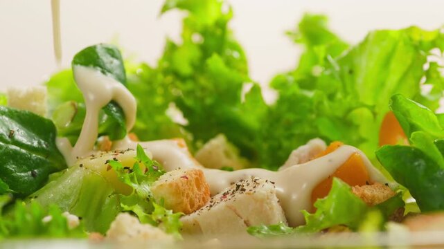 Caesar Dressing or Creamy Sauce Pouring Over Fresh Green Caesar Salad Leaves in Bowl, Close Up of Healthy Food Preparation, Restaurant and Cafe Cooking Concept