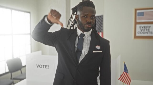 Man in suit giving thumbs down beside a voting booth with vote sign and a small united states flag inside a polling station; disapproval civic critique.