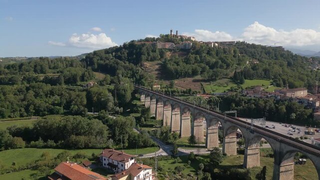 Aerial view of Mondovi railway bridge with hilltop old town in background on warm sunny afternoon

