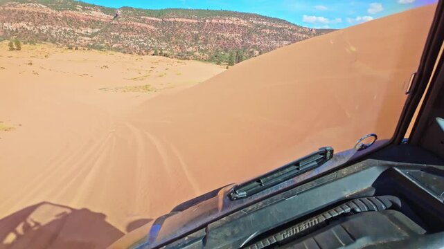 Golden sunset light glows as an ATV rides through Coral Pink Sand Dunes State Park in Utah