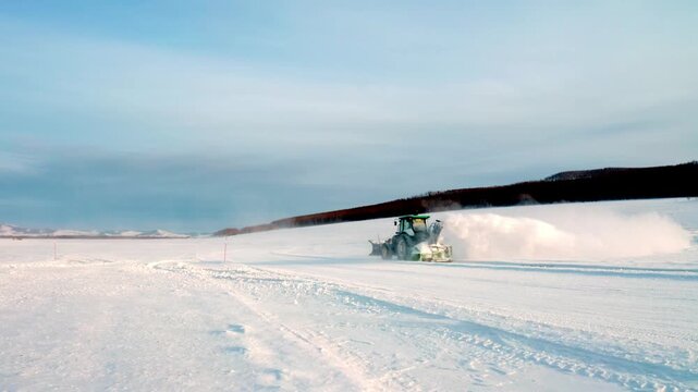 Snow Blower Tractor Throwing a High Plume of Powder