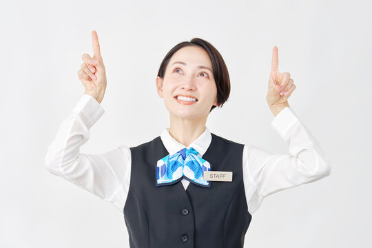 上を指差す女性スタッフ　受付嬢・銀行員　白背景