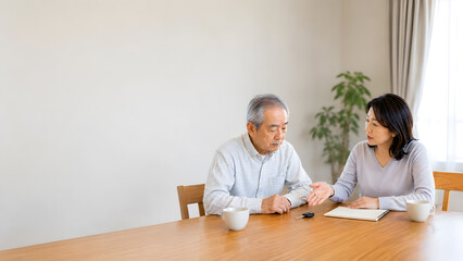 Obraz premium 食卓で免許返納の相談をする高齢男性と中年女性 父娘のイメージ