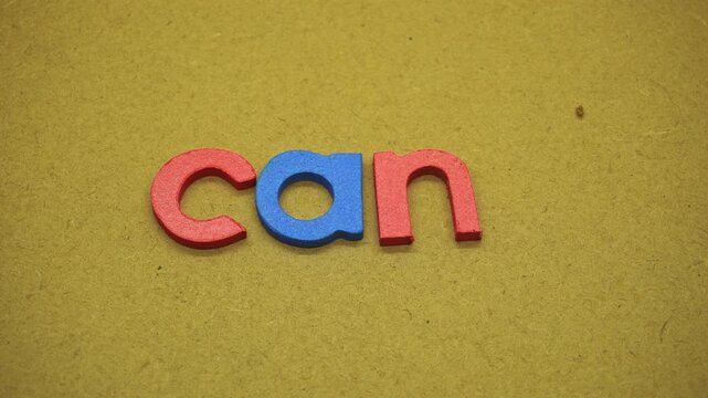 Hand removing letter t from word cant to make can on textured paper background, representing positive mindset, motivation, determination, confidence, and self belief concept.