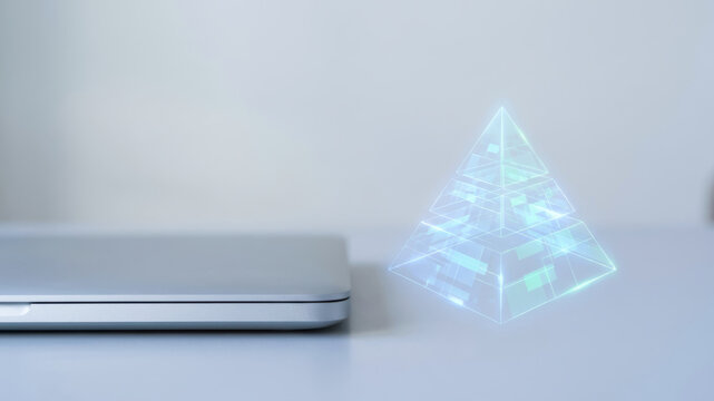 Laptop with holographic pyramid for data driven decision making in modern technology workspace with cool lighting and digital innovation concept