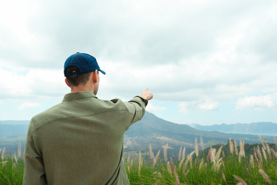 A person shows the view of the Kintamani mountains in Bali